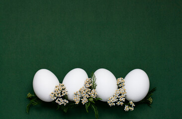 Festive Easter eggs with white small flowers on a green background. - 519196847
