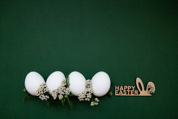 Festive Easter white eggs with white small flowers on a green background. - 519198083