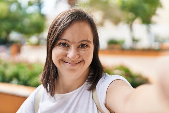 Down syndrome woman smiling confident making selfie by the camera at park