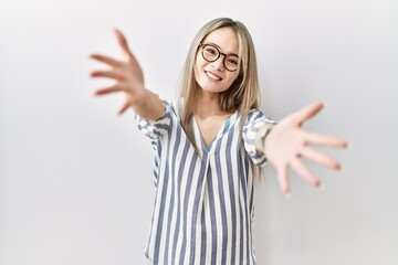 Asian young woman wearing casual clothes and glasses looking at the camera smiling with open arms for hug. cheerful expression embracing happiness.