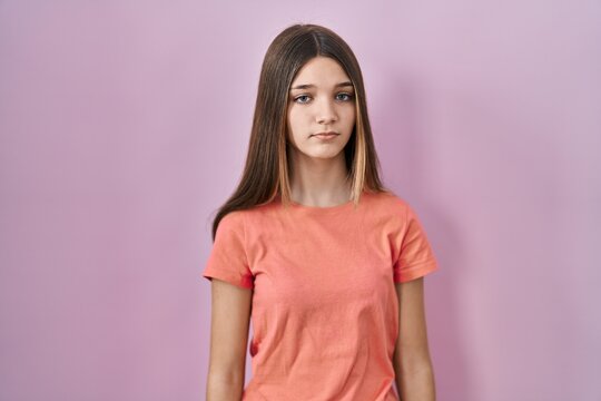 Teenager girl standing over pink background looking sleepy and tired, exhausted for fatigue and hangover, lazy eyes in the morning.