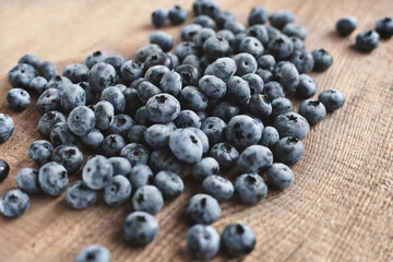 Fresh blueberries scattered on the wooden board. Selective focus.