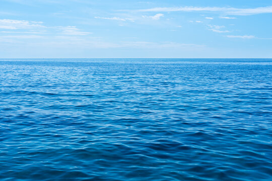 Beautiful seascape with blue sea and blue sky with clouds on the horizon. Natural wallpaper. Selective focus.