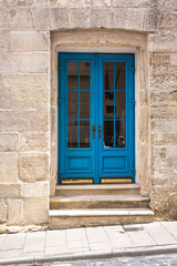 Facade of an old building with blue doors.