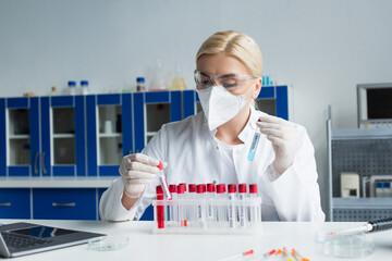 Scientist holding test tubes with antigen and monkeypox lettering in laboratory.