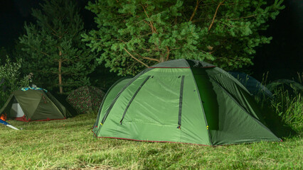 Tents camping area. Camping and tent. Tourist tent stands under the tree at night. Travel and adventure concepts.