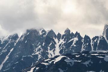 Amazing high rocks in a snow at the sunset. Mountains landscape