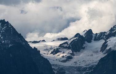 Fototapeta premium Beautiful snow covered mountains with in the fog and dramatic clouds.
