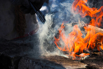 Blacksmith heats metal in a opened furnace
