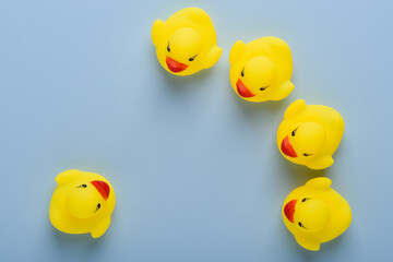 One rubber duck in front of group, announcement, education or meeting concept, on blue background top view