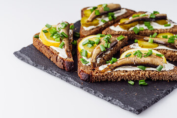 canapes with sprats on a black stone tray