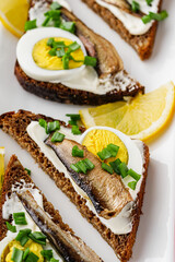 canapes with sprats on a white rustic wooden background