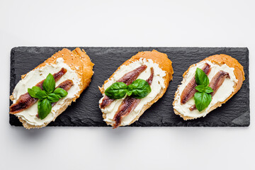 sandwich with anchovy fillets on a serving tray on a white background