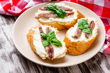 sandwich with anchovy fillet on a tray for serving on a wooden rustic background