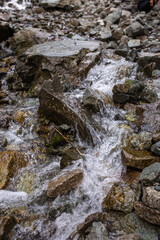 the mountain river flows quickly over the stones