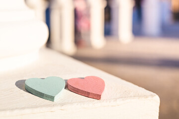 two wooden hearts on a white stone surface
