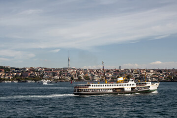 View of traditional ferry boat on Bosphorus and Asian side of Istanbul. It is a sunny summer day.