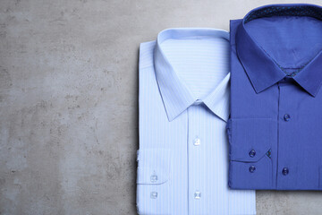 Stylish shirts on grey background, flat lay. Dry-cleaning service
