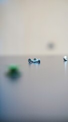 small bolts plus silver on the table on a blurred background