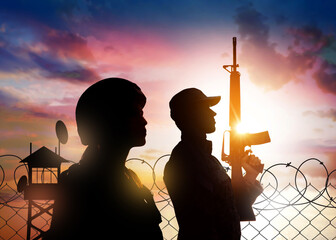 Silhouettes of border guards at post outdoors in early morning