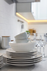 Different clean dishware, cups and glasses on countertop in kitchen