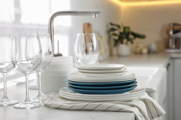 Different clean dishware and glasses on countertop in kitchen