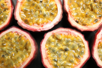 Halves of passion fruits (maracuyas) on table, flat lay