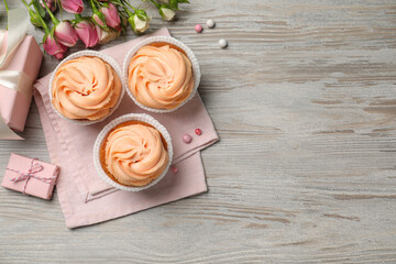 Flat lay composition with tasty cupcakes on white wooden table. Space for text