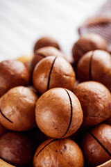fresh macadamia nuts on a white wooden rustic background