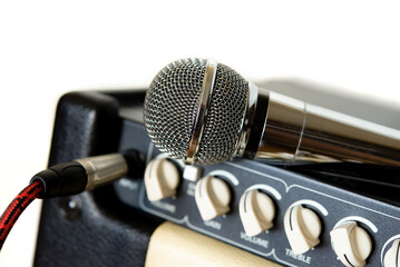 Details of combo amplifier for electric guitar or microphone. Musical theme.