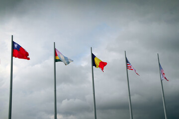 Flags of different countries on high flagpoles