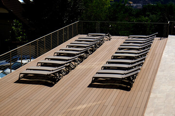 Empty terrace with sun beds and wooden brown floor deck