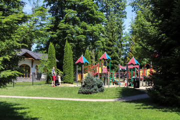 RABKA-ZDROJ, POLAND - 18 JULY 2022: A playground for kids in public park of Rabka-Zdroj, Poland. - obrazy, fototapety, plakaty