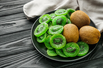 green dried kiwi on a black wooden rustic background