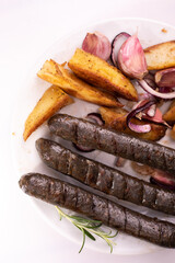 Close-up of grilled, roasted vegan, vegetarian sausages on a plate. Composition with buckwheat blood sausages, isolated