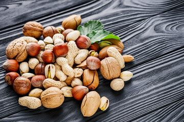 set of different nuts on a black rustic wooden background