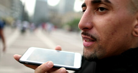 Hispanic man talking on smartphone in conversation in downtown city