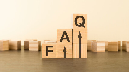faq on wooden cubes over yellow background with copy space, financial concept