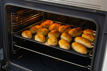 homemade pies on a baking sheet in the oven, close-up