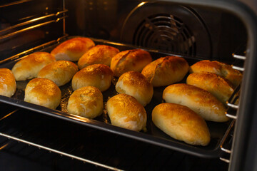 homemade pies on a baking sheet in the oven, close-up