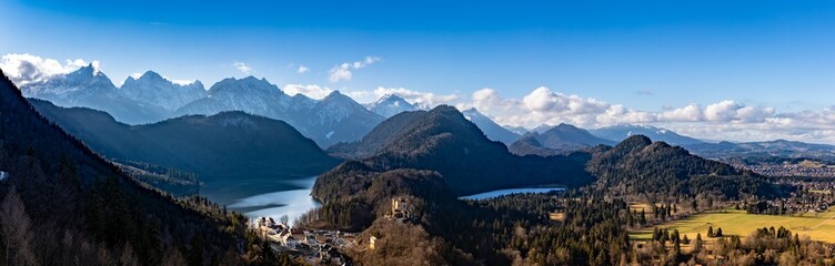 Fototapeta na wymiar Panorama view of the Bavarian Alps and Lake with the famous Hohenschwangau Castle and Alpsee lake, Schwansee lake on a sunny day in winter, Schwangau, Bavaria, Germany