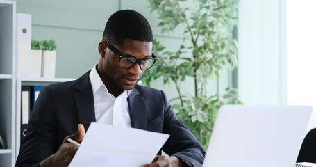 African american businessman engaged in online conference using laptop at office