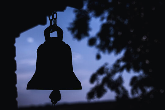 ancient bell silhouette in church, place of relaxation and worship, religion concept at sunset
