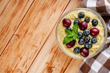 sweet porridge with quinoa and berries on a wooden rustic background