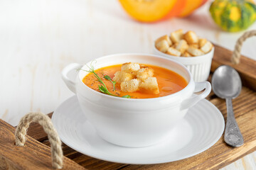 Pumpkin soup with croutons 0n white background. Copy space