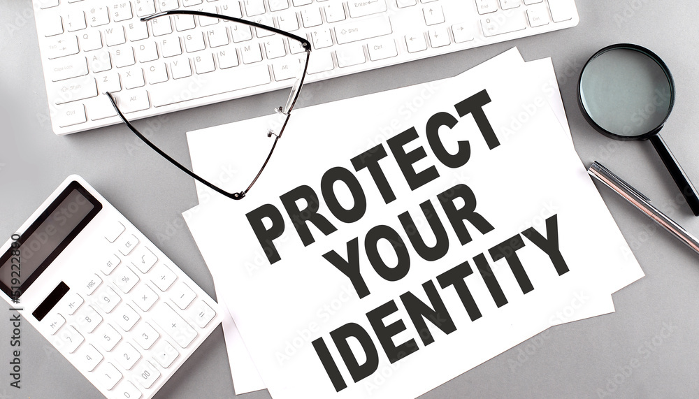 Poster protect your identity text on paper with keyboard, calculator on grey background