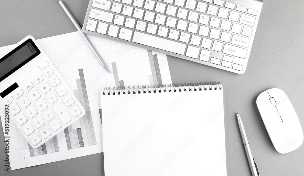 Poster blank notebook with keyboard, chart, calculator and supplies on grey background . top view with copy