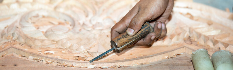 close-up carpenter man's hand treats the tree, cuts the shavings. Copy space. woody curl. Manual processing of wood in the workshop. joiner woodworker in process.
