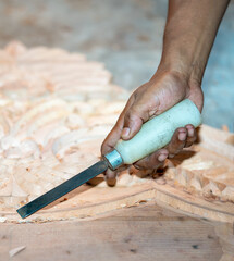 close-up carpenter man's hand treats the tree, cuts the shavings. Copy space. woody curl. Manual processing of wood in the workshop. joiner woodworker in process.
