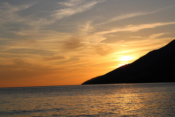 Fototapeta na wymiar Sunset at the beach with mountain